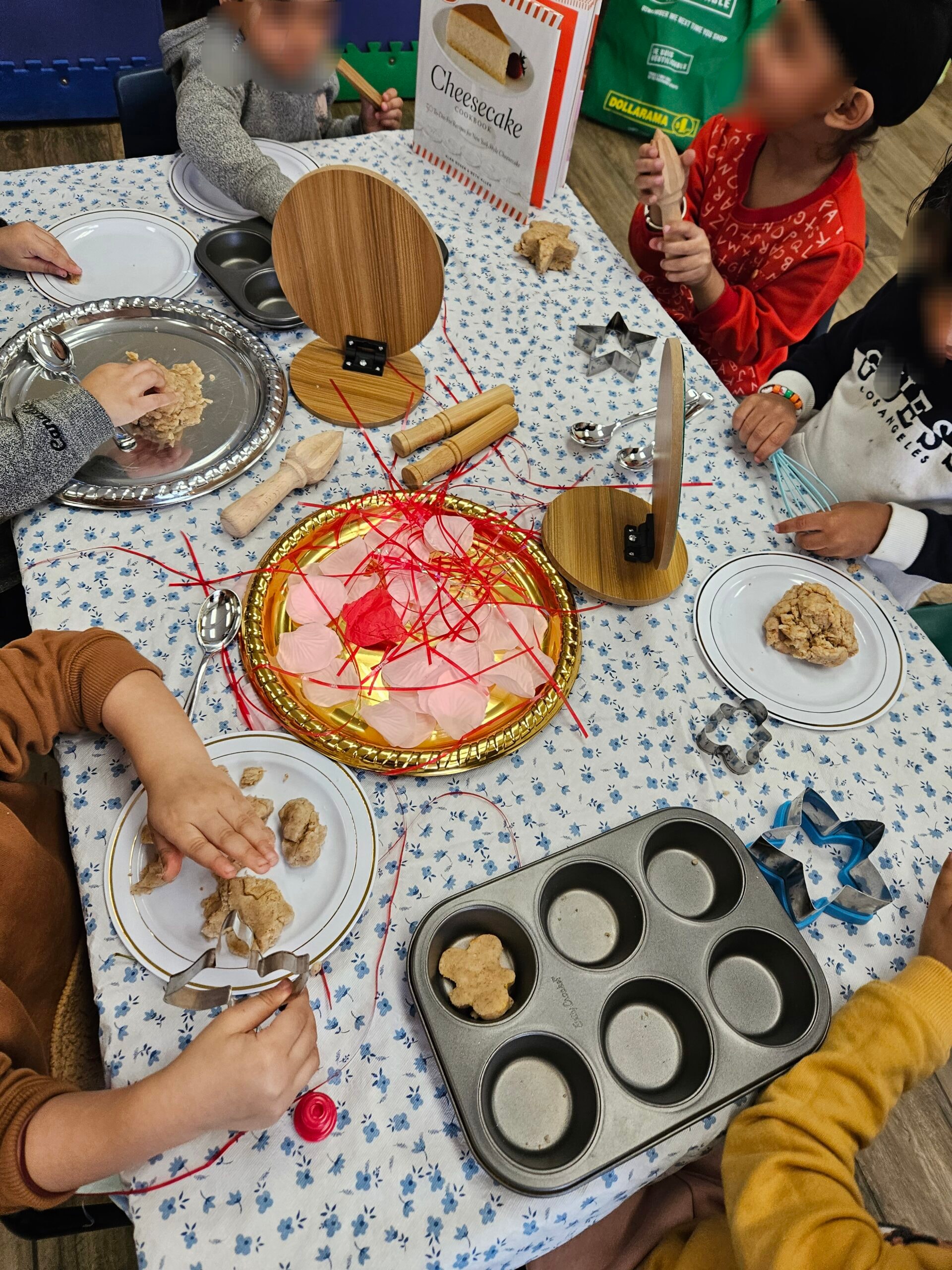 Children doing a playdough baking activity at a table with baking tools