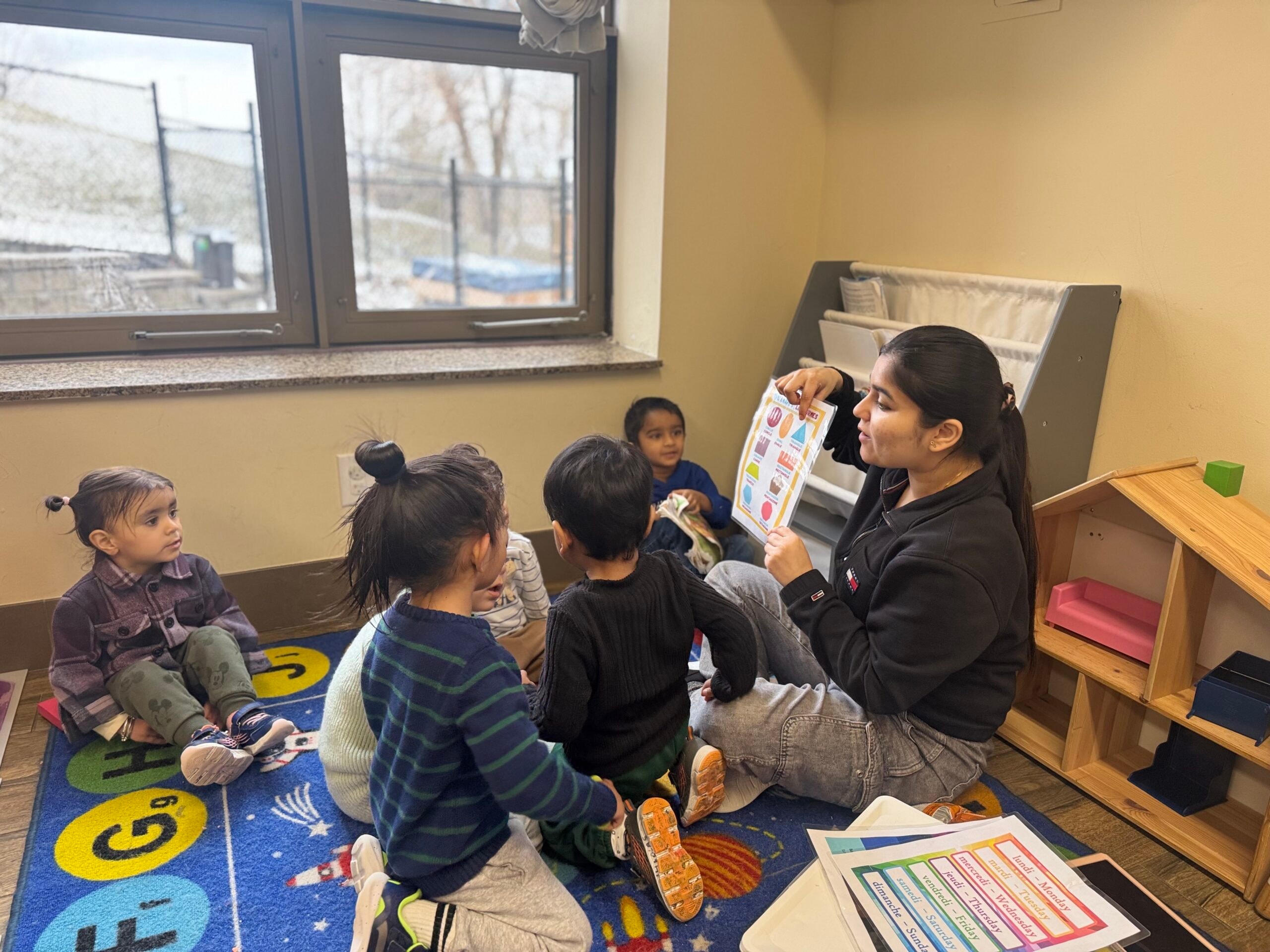 Educator reading and showing a shapes chart to a group of toddlers